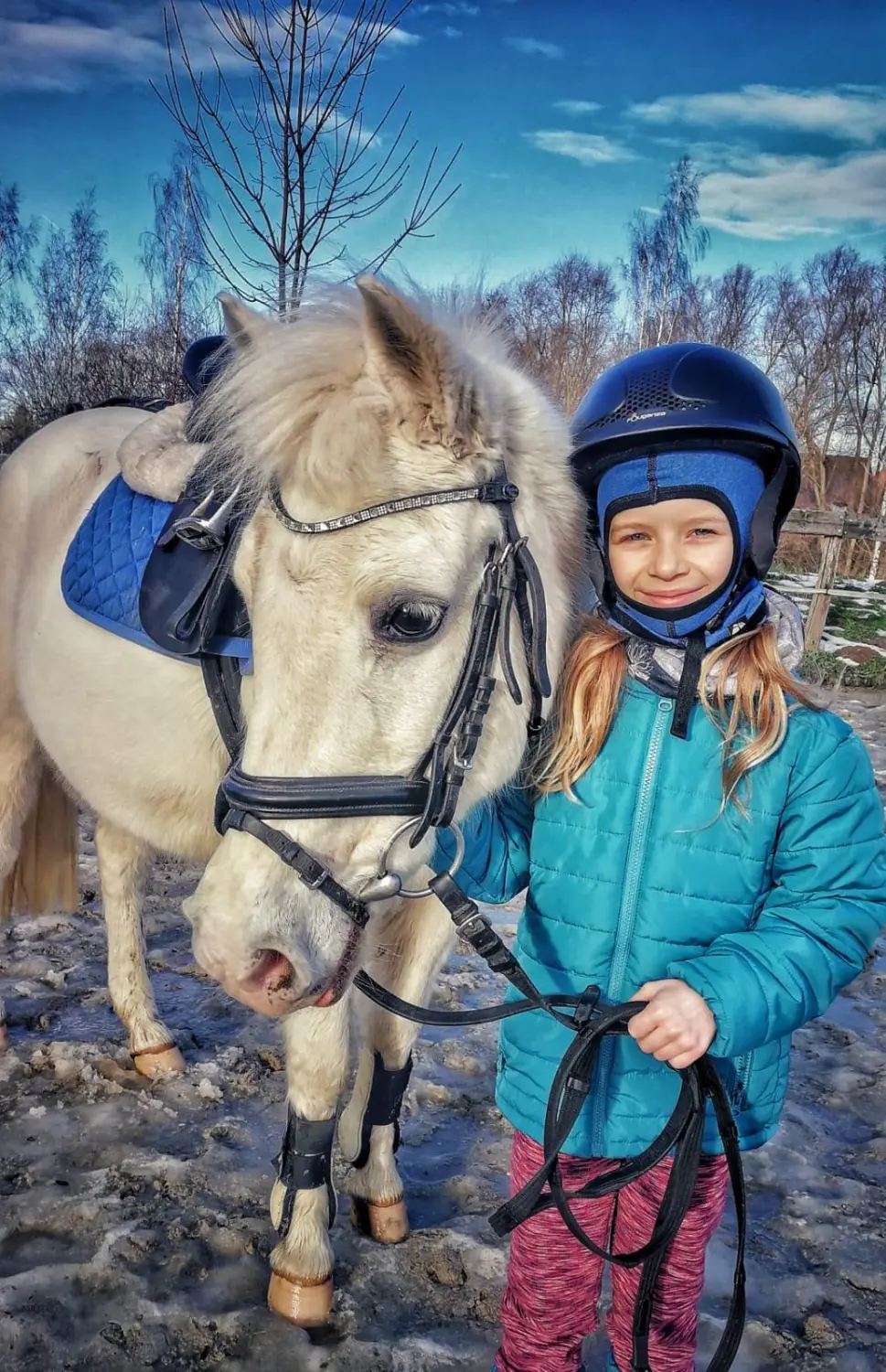 Reitsport Bachmann - kleines Mädchen stehend mit Pony