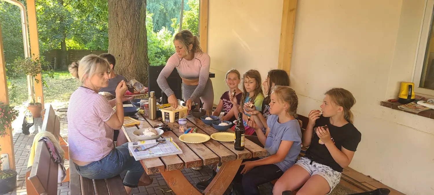 Reitsport Bachmann - eine Frau bedient Kinder am Esstisch
